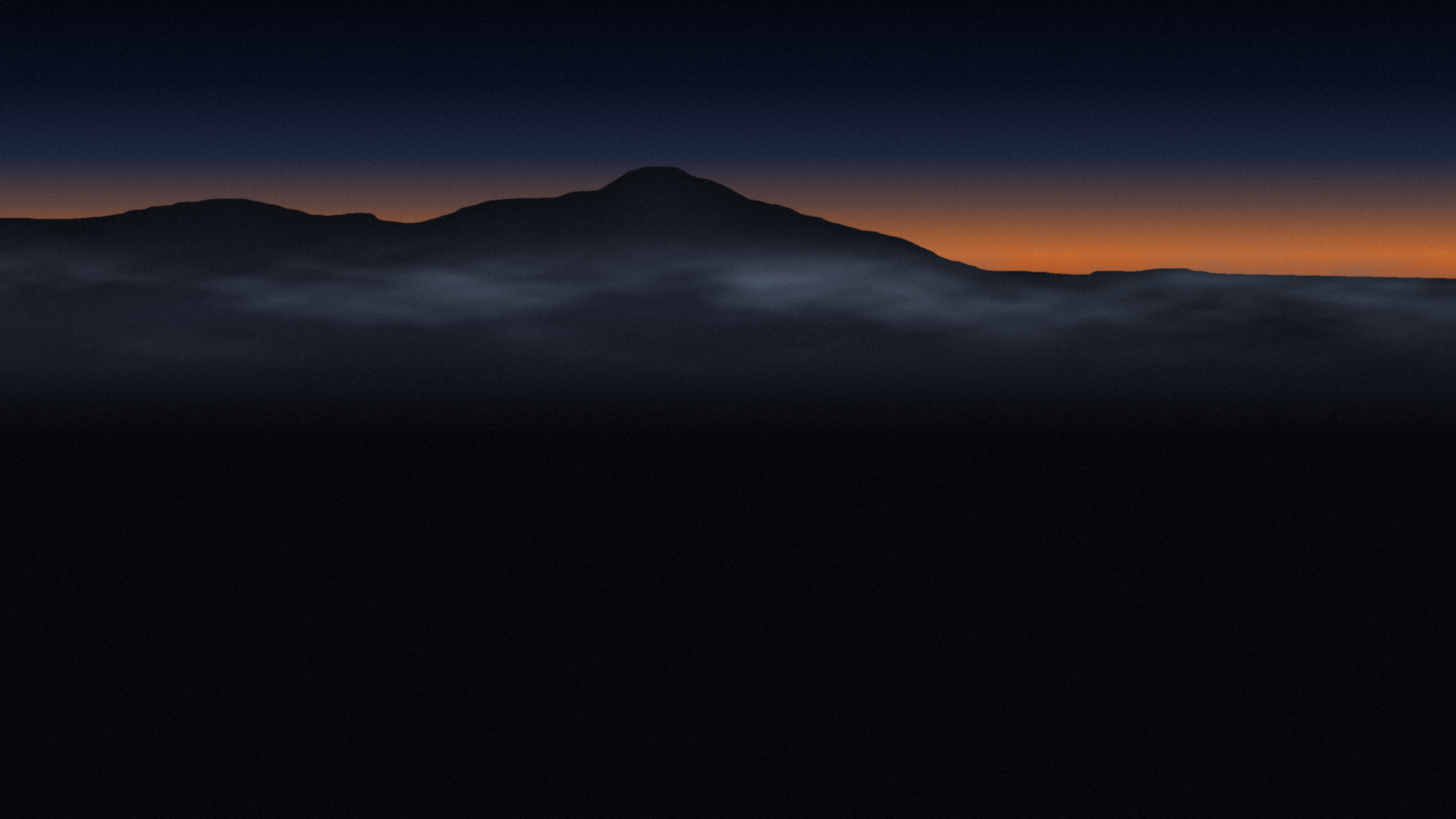 Mt. Tamalpais at dusk, its outline above a layer of fog